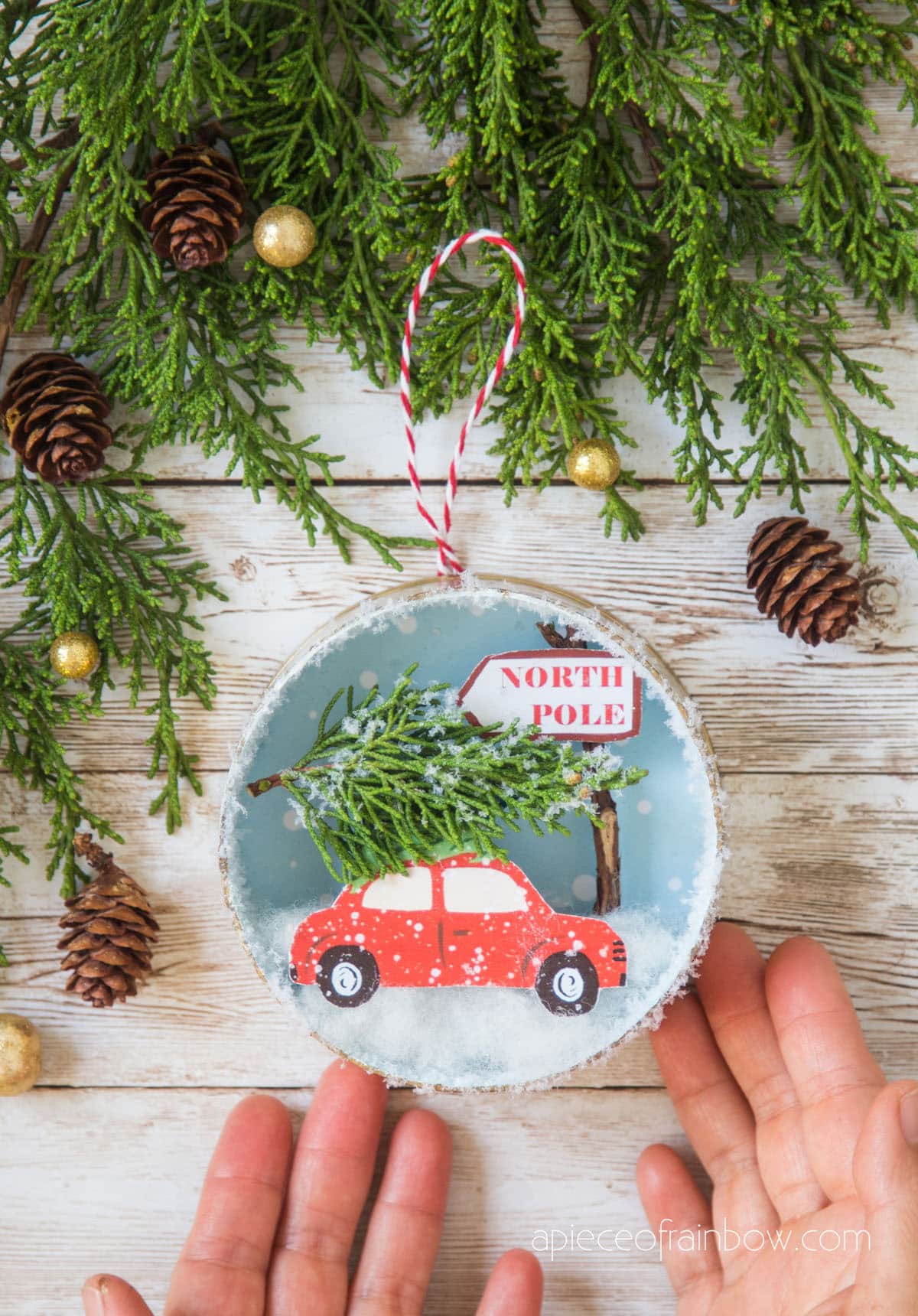 red car with Christmas tree on top with winter snow scene in an ornament