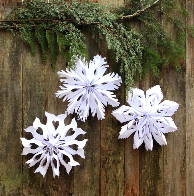 Make giant lighted snowflake pendants from paper bags or white paper. Easy tutorial with free templates. Beautiful decor for holidays and year round!  
