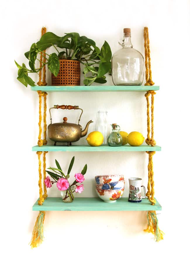 Easy to build and hang, this beautiful gold and turquoise DIY rope shelf is also collapsible. All you need is a drill to build it!