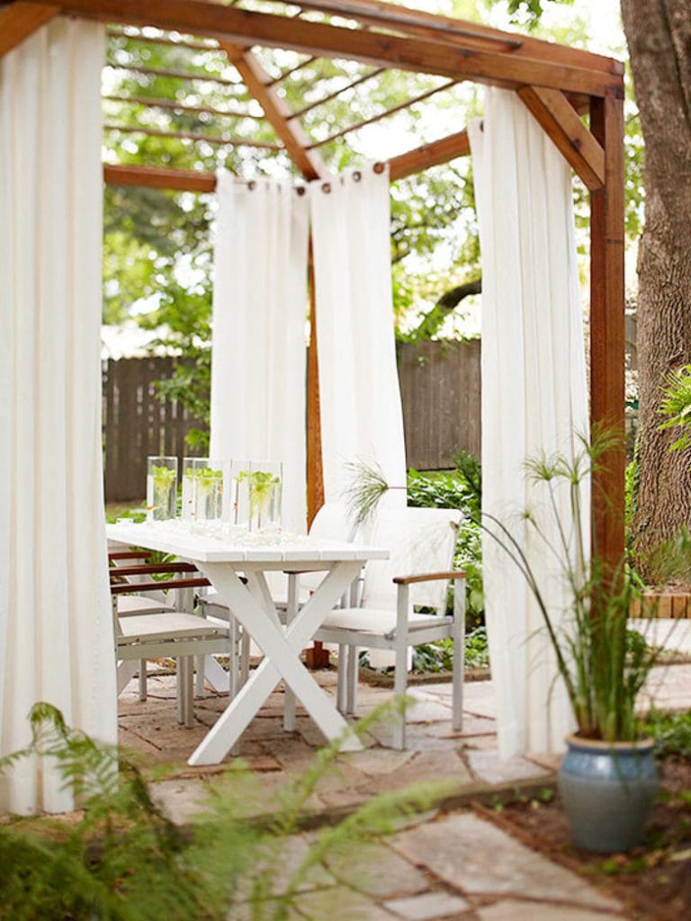 white fabric curtains on outdoor wood pergola