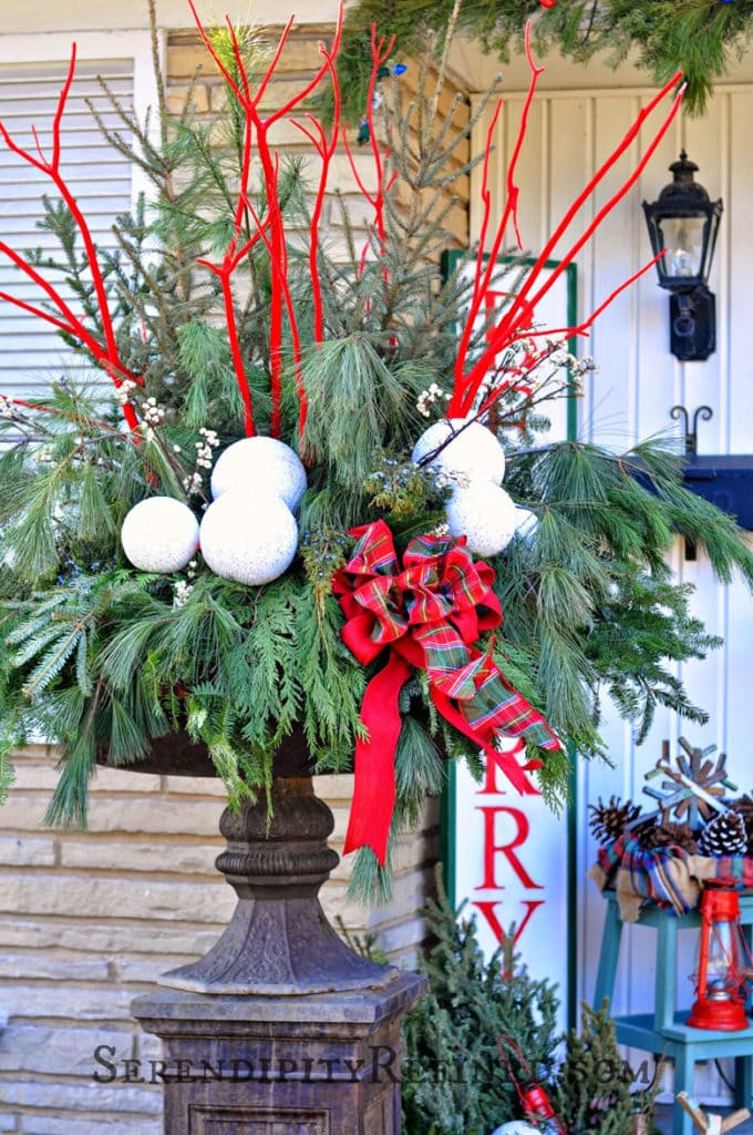 painted red branches in a Christmas planter urn