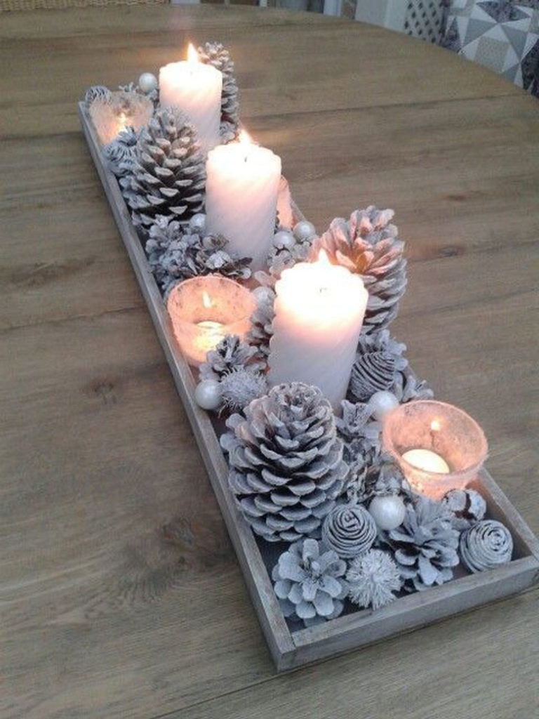 Snowy Christmas table centerpiece ideas with white pine cones in wood tray
