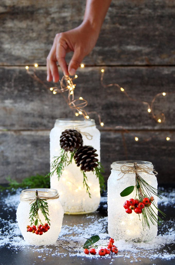 add Christmas string lights in DIY snow frosted mason jar table decorations
