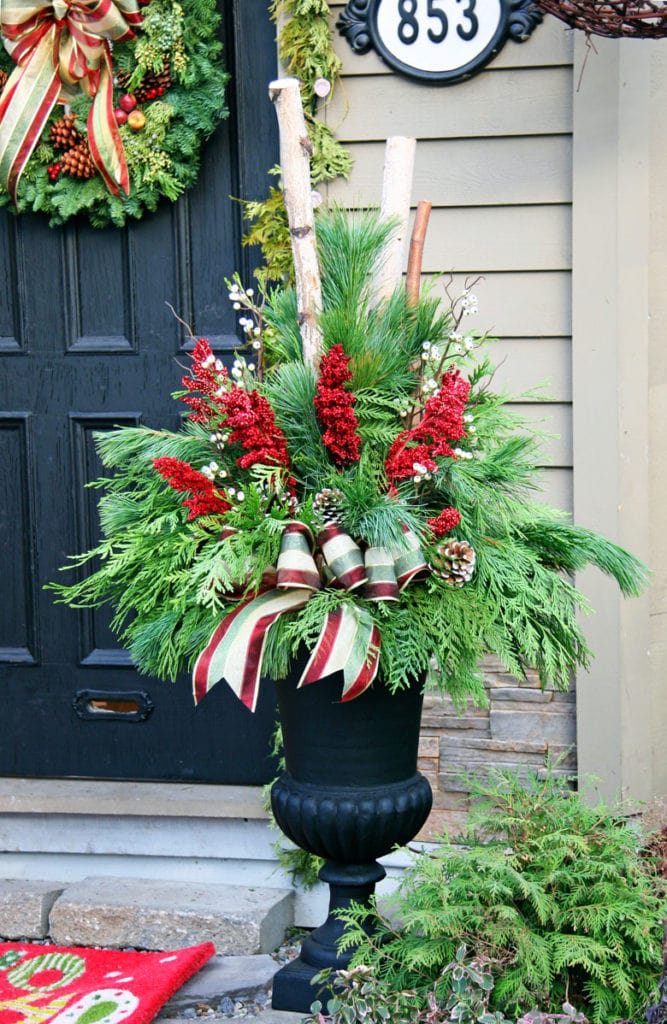 Christmas porch planter decorations by the front door using colorful ribbons and pine cones