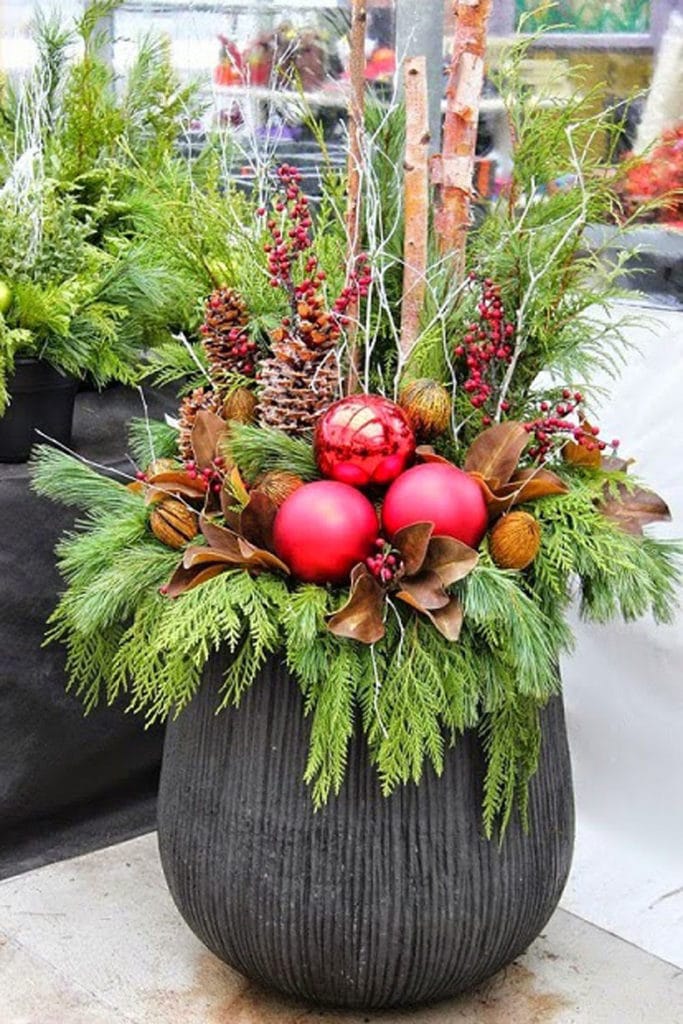 colorful Christmas ornaments in outdoor winter planter